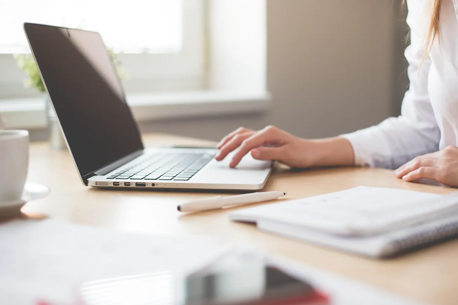 Podnikateľ pracuje na notebooku s otvorenou webstránkou alebo e-shopom Podnikateľ pracuje na notebooku s otvorenou webstránkou alebo e-shopom